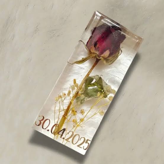 A rose with its stem and a special date preserved in a rectangular clear resin keepsake